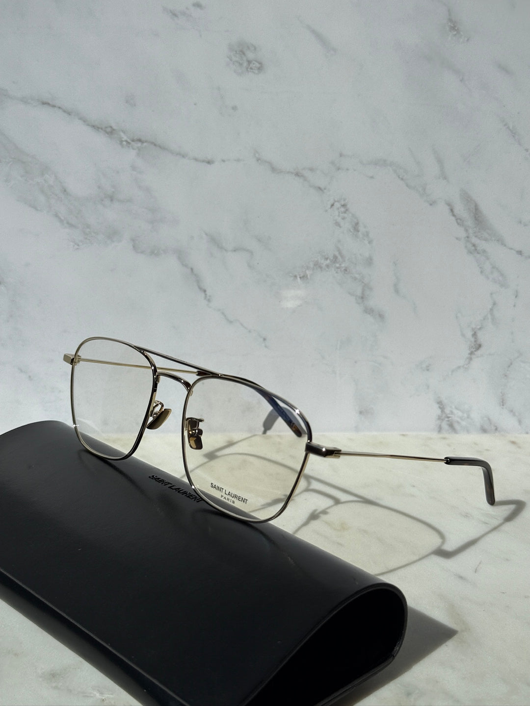 Gold aviator eyeglass frames with clear lenses and adjustable nose pads.