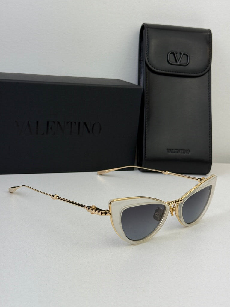White cat-eye sunglasses with gold-tone arms and gray lenses with black case