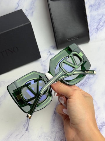 Green sunglasses with V-soul bridge and mirrored lenses, shown in hand