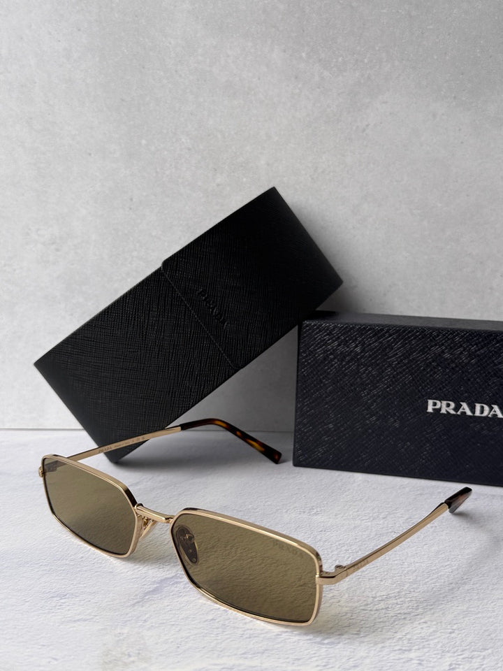 Gold metal rectangular sunglasses with brown-tinted lenses, side view, black case.