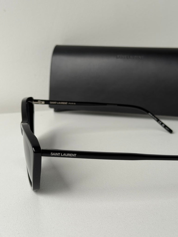 Black cat-eye sunglasses with dark lenses and SAINT LAURENT logo temple