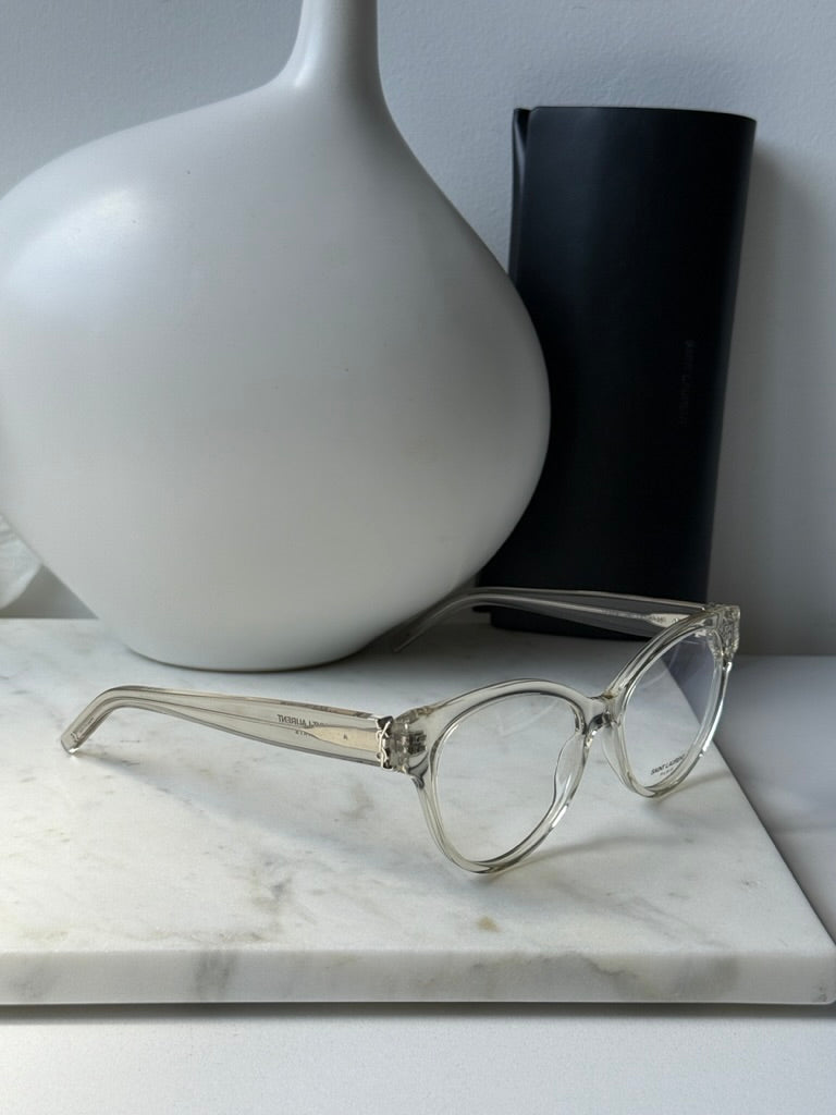 Clear Saint Laurent eyeglass frames with hinged arms and metal accents, side view