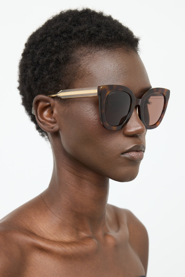 Gucci cat-eye sunglasses on model, Havana brown frames with dark lenses