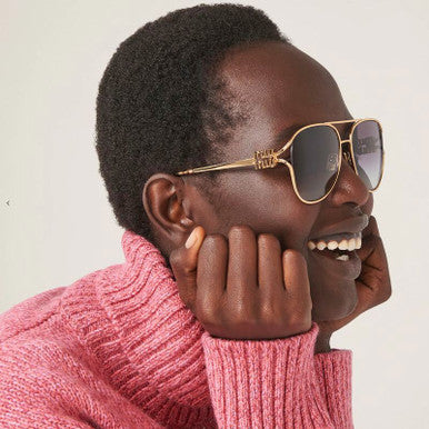 Miu Miu gold aviator sunglasses with dark lenses and bow-shaped temple detail