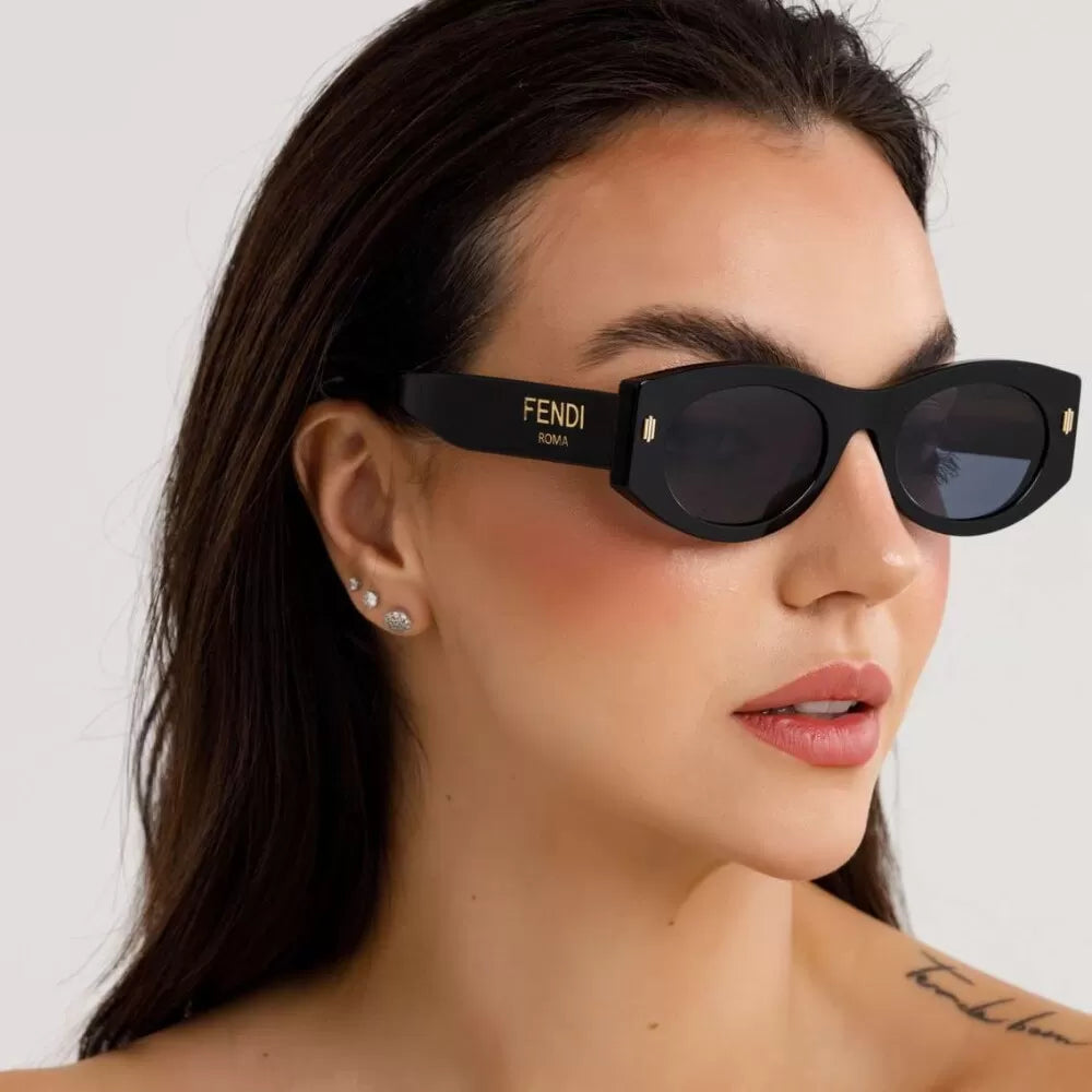 Black cat-eye sunglasses with dark lenses and FENDI logo on side, worn