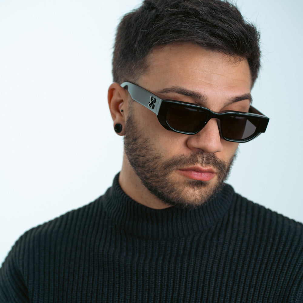 Black Greeley sunglasses with dark lenses on man, logo on temple