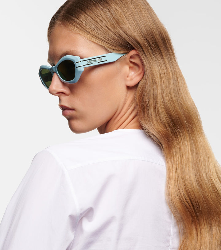 Dior light blue cat-eye sunglasses on model, dark green lenses