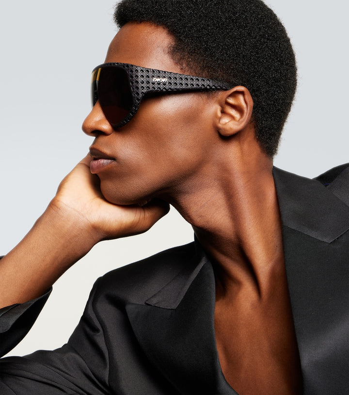 Man wearing Dior black wrap sunglasses with perforated frame and dark lenses