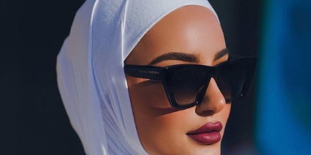 Black cat-eye sunglasses with dark lenses and red temple tips