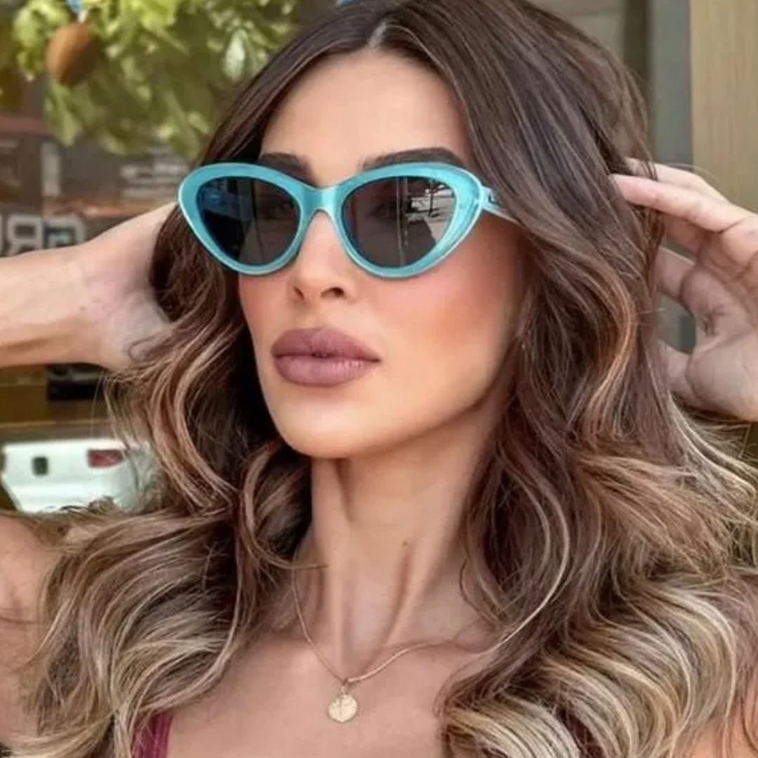 Gucci cat-eye sunglasses on model, turquoise frame and dark mirrored lenses