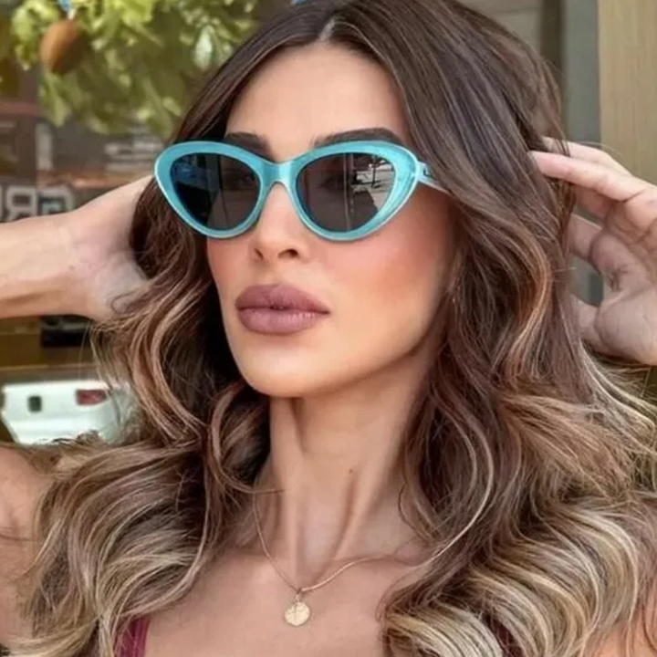 Gucci cat-eye sunglasses on model, turquoise frame and dark mirrored lenses