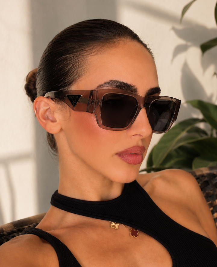 Prada PR10ZS sunglasses worn on face, transparent frame with dark lenses