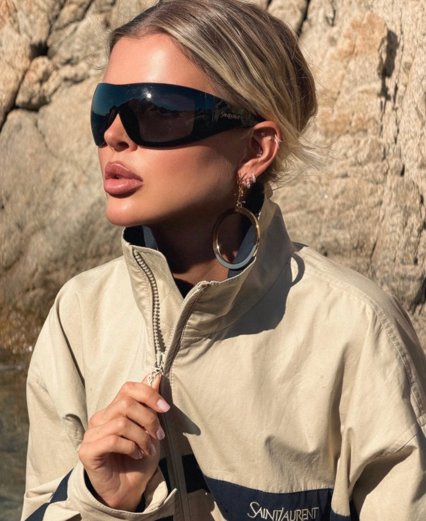 Black mask sunglasses with dark lenses on model, Saint Laurent logo at temple