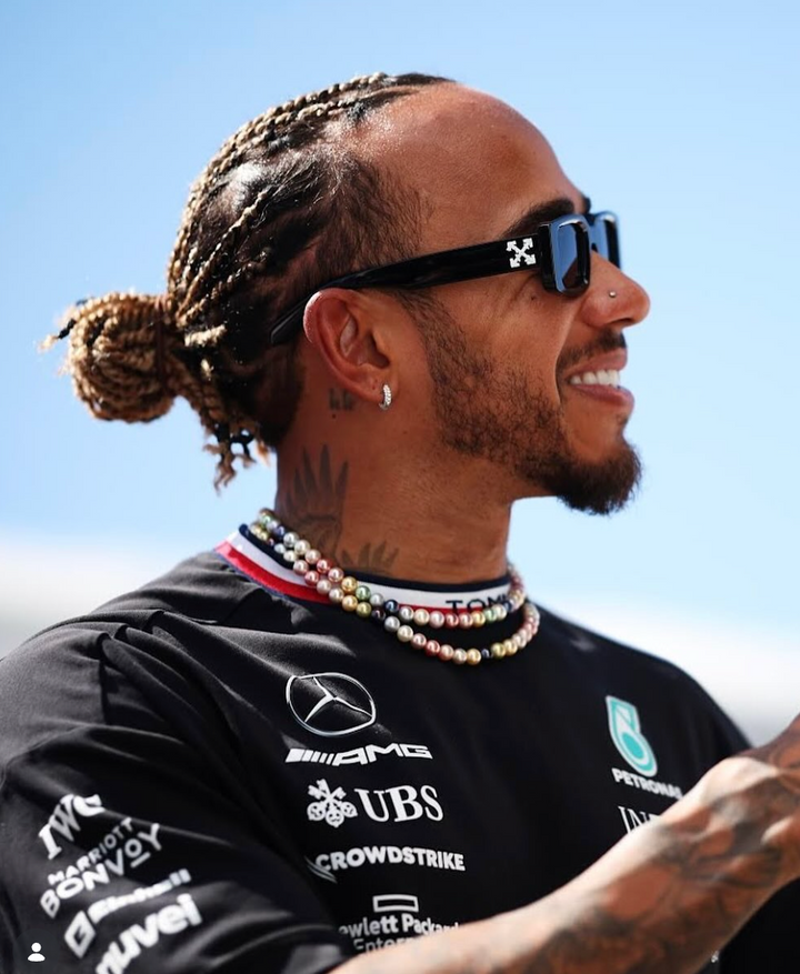 Black sunglasses with blue tinted lenses worn in side profile