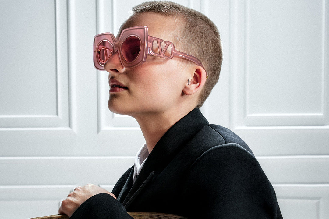 Pink sunglasses with chunky V-frame and gradient tinted lenses, worn on face