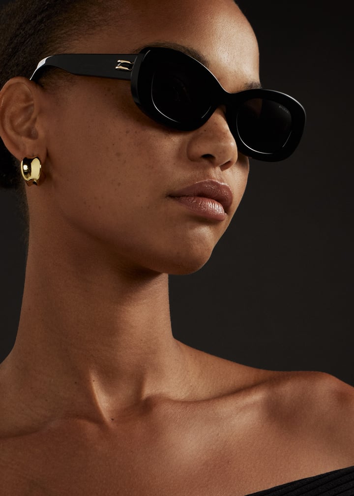 Black round sunglasses with dark lenses, worn on face with side profile