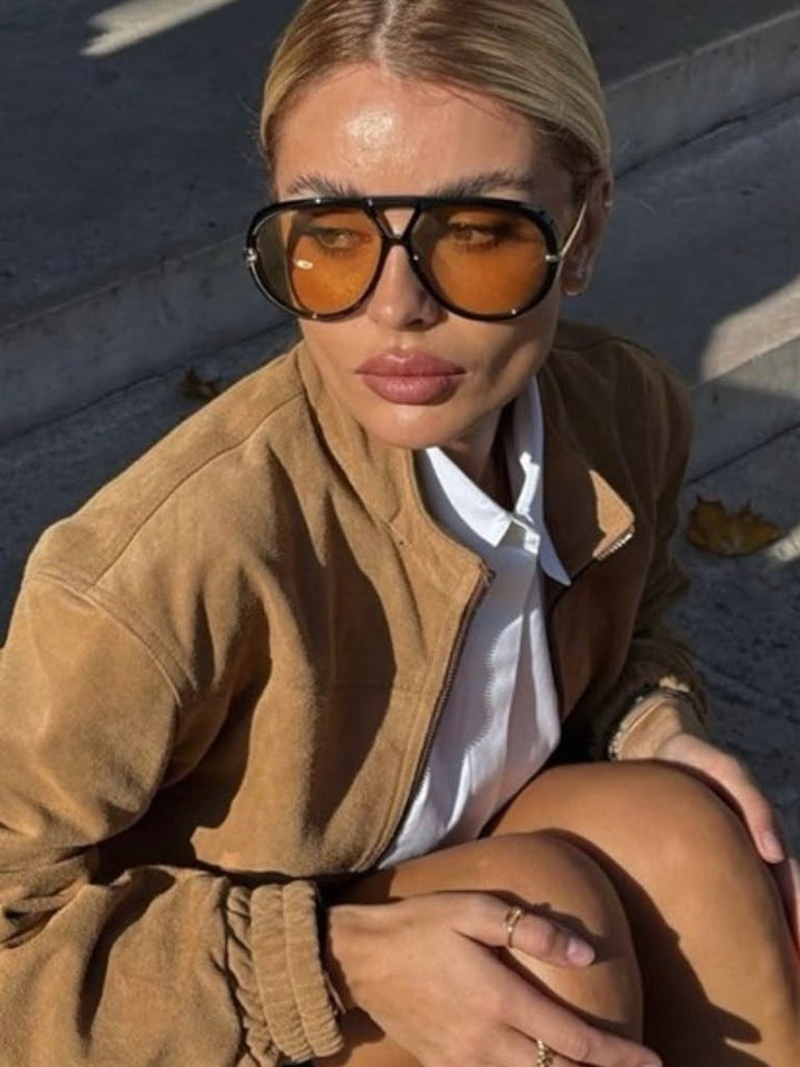 Black aviator sunglasses with amber-tinted lenses and black frames