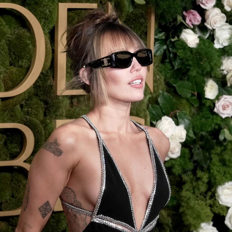Celine sunglasses on model: blackish square frames with gold logo detail on temples