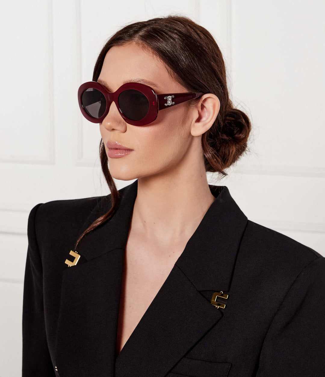 Celine oval sunglasses on a woman, dark lenses, nude-beige frames, gold side logo