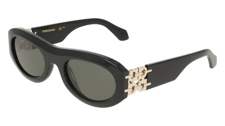 Black cat-eye sunglasses with metal emblem on temple and tinted green lenses