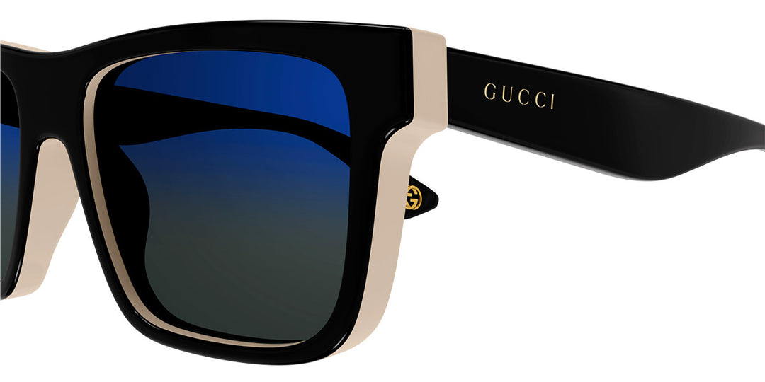 Gucci black sunglasses close-up with blue mirrored lenses and GG logo on arm