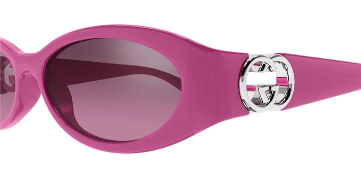 Gucci pink oval sunglasses with logo emblem on side and tinted lens