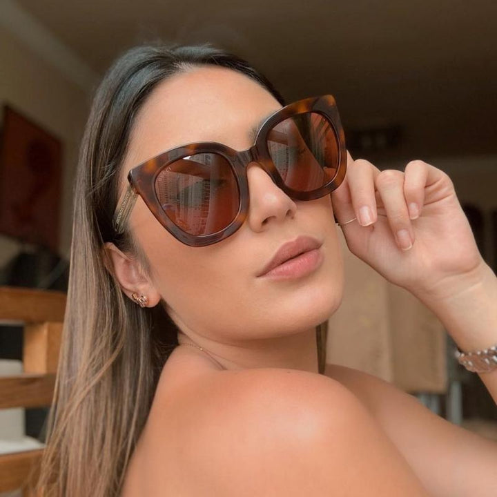 Gucci cat-eye sunglasses worn by model, tortoiseshell frames with tinted lenses