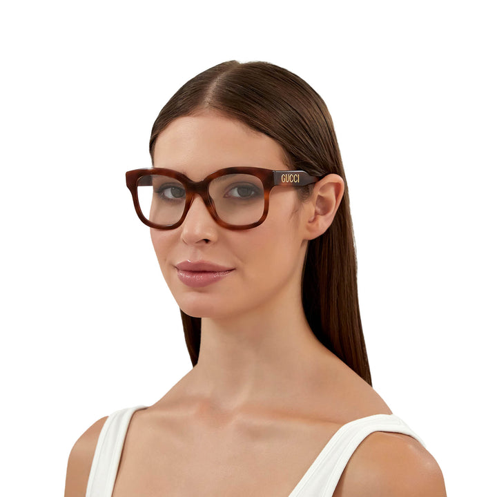 Gucci Havana brown eyeglasses on model, rectangular frames with GUCCI temple logo