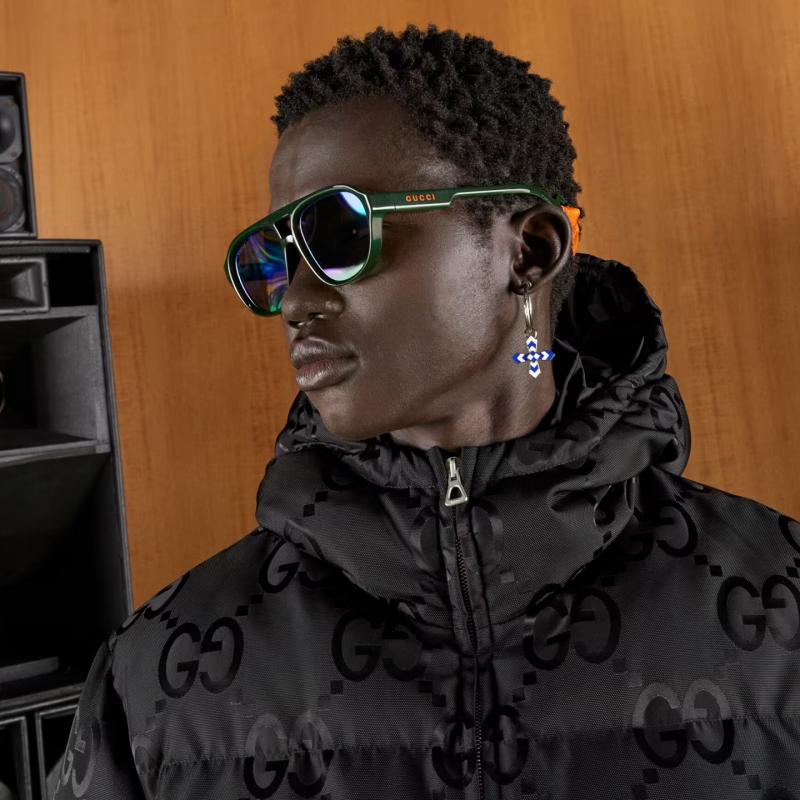 Green aviator sunglasses with multicolor mirror lenses worn with a black GG jacket