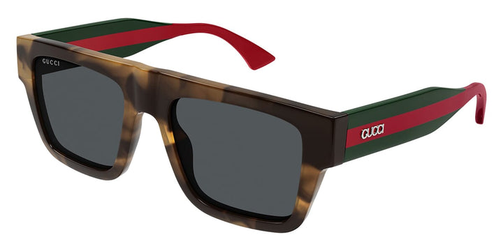 Unisex Gucci sunglasses, brown frames, dark lenses, striped temple arms