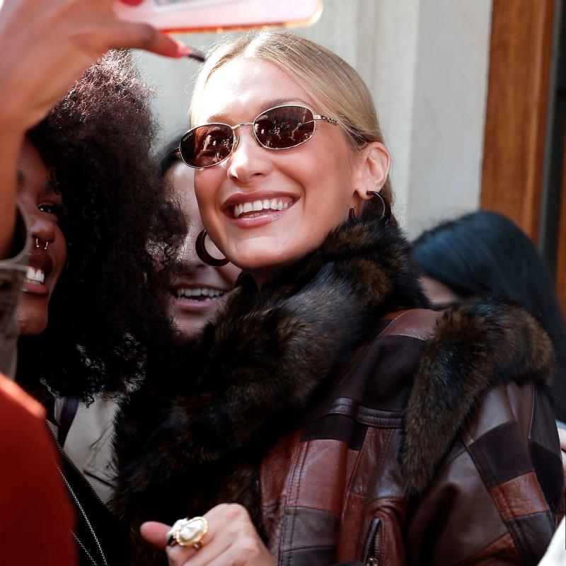 Gucci oval logo sunglasses on a woman, dark brown lenses and gold-tone frame