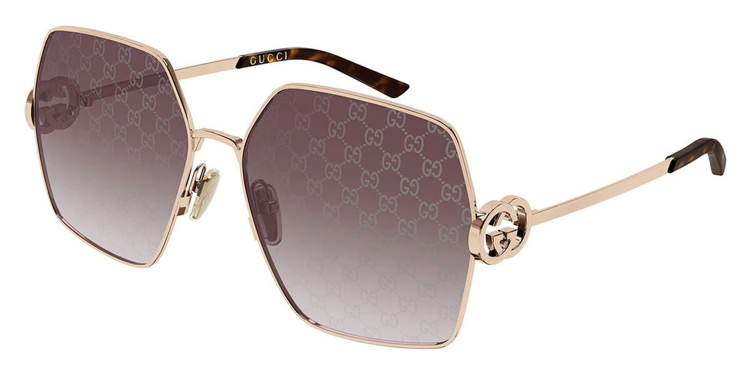 Oversized rose gold metal sunglasses with dark gradient lenses and logo-pattern frames