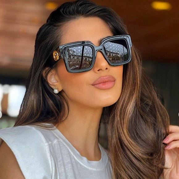 Gucci black square sunglasses on model, dark lenses and GG logo temple