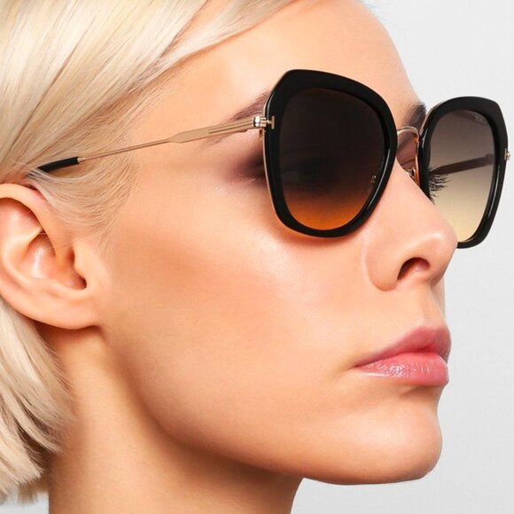 Tom Ford black and gold sunglasses worn in side profile, dark tinted lenses