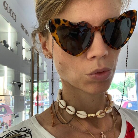 Tortoiseshell cat-eye sunglasses with dark lenses, side view on model