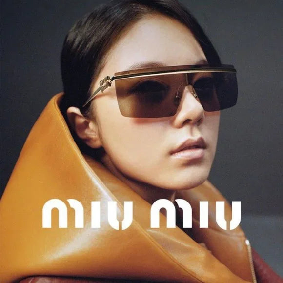 Miu Miu sunglasses on face, gold frame with dark tinted lenses