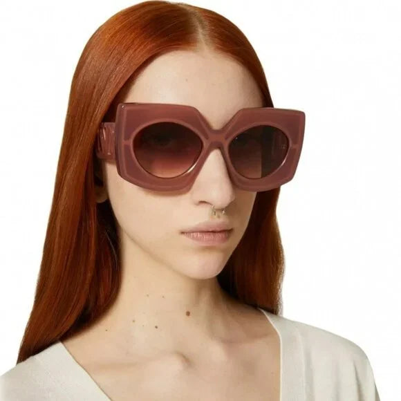 Pink square sunglasses with thick frame and dark lenses on a woman