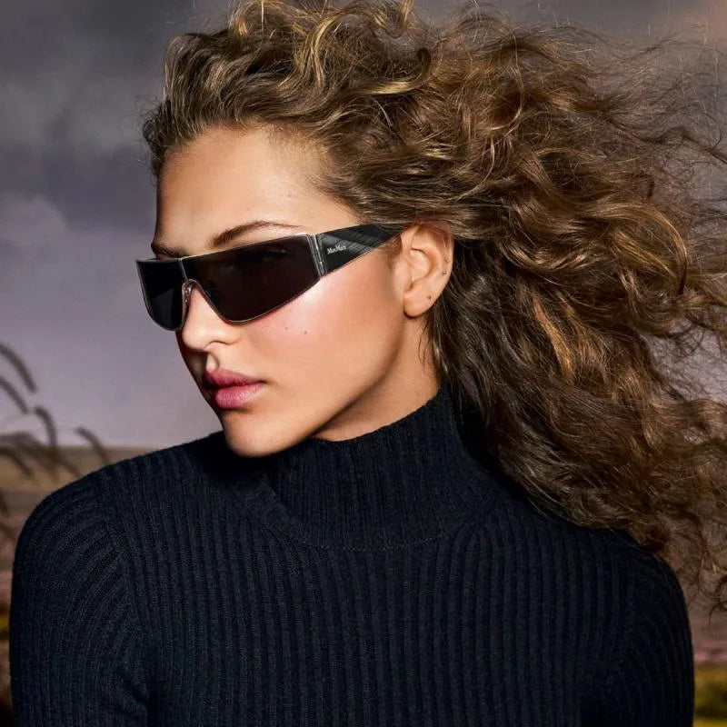 Dark shield sunglasses with gold-tone trim and patterned brown arms, shown worn.
