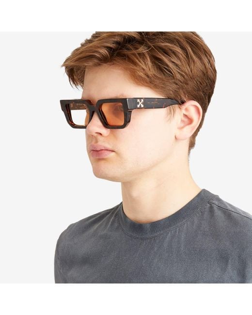 Dark tortoise square sunglasses worn by a person, side profile view.