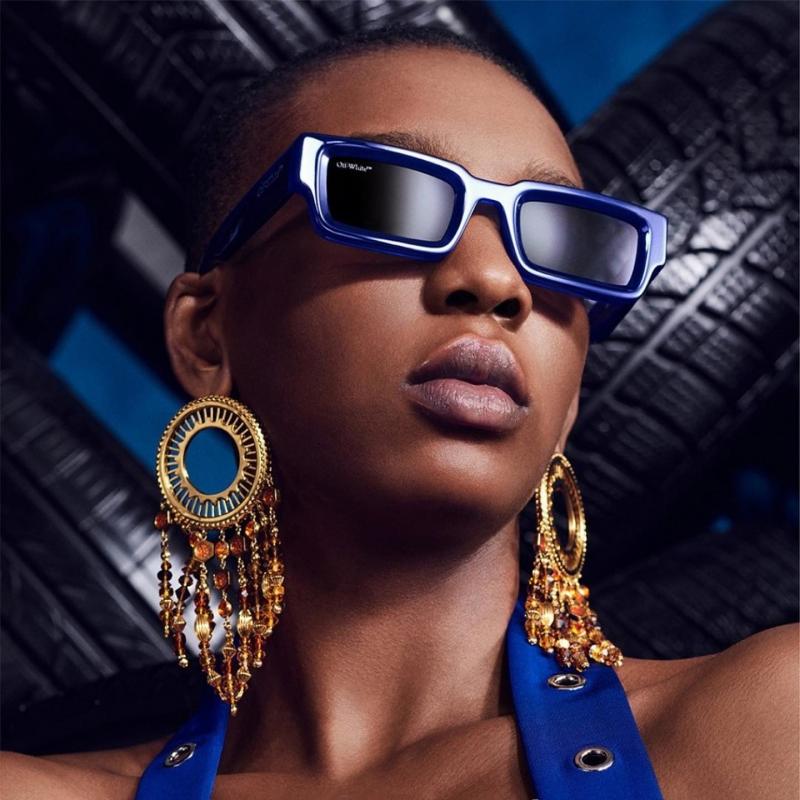 Blue square sunglasses with dark lenses and Off-White logo, worn on a model.