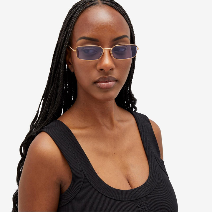 Prada sunglasses on model: purple-tinted lenses in thin brass metal frames