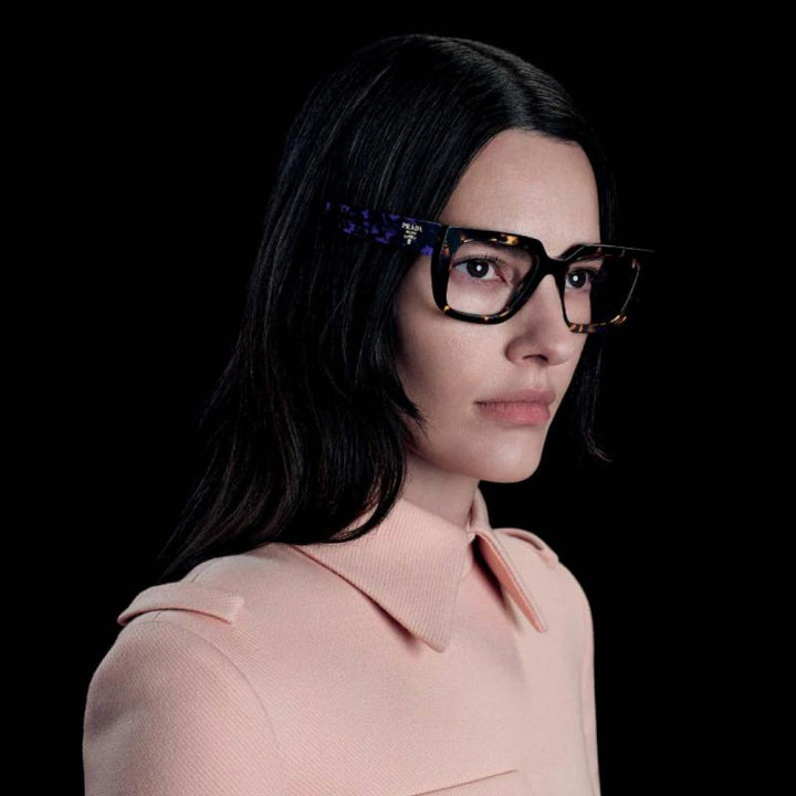 Prada black rectangular eyeglasses on model, logo on temple, dark lenses