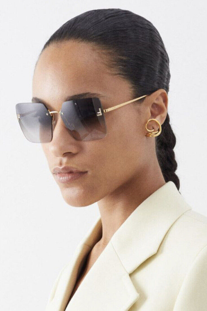 Rimless gradient sunglasses, gold temples and grey square lenses on model
