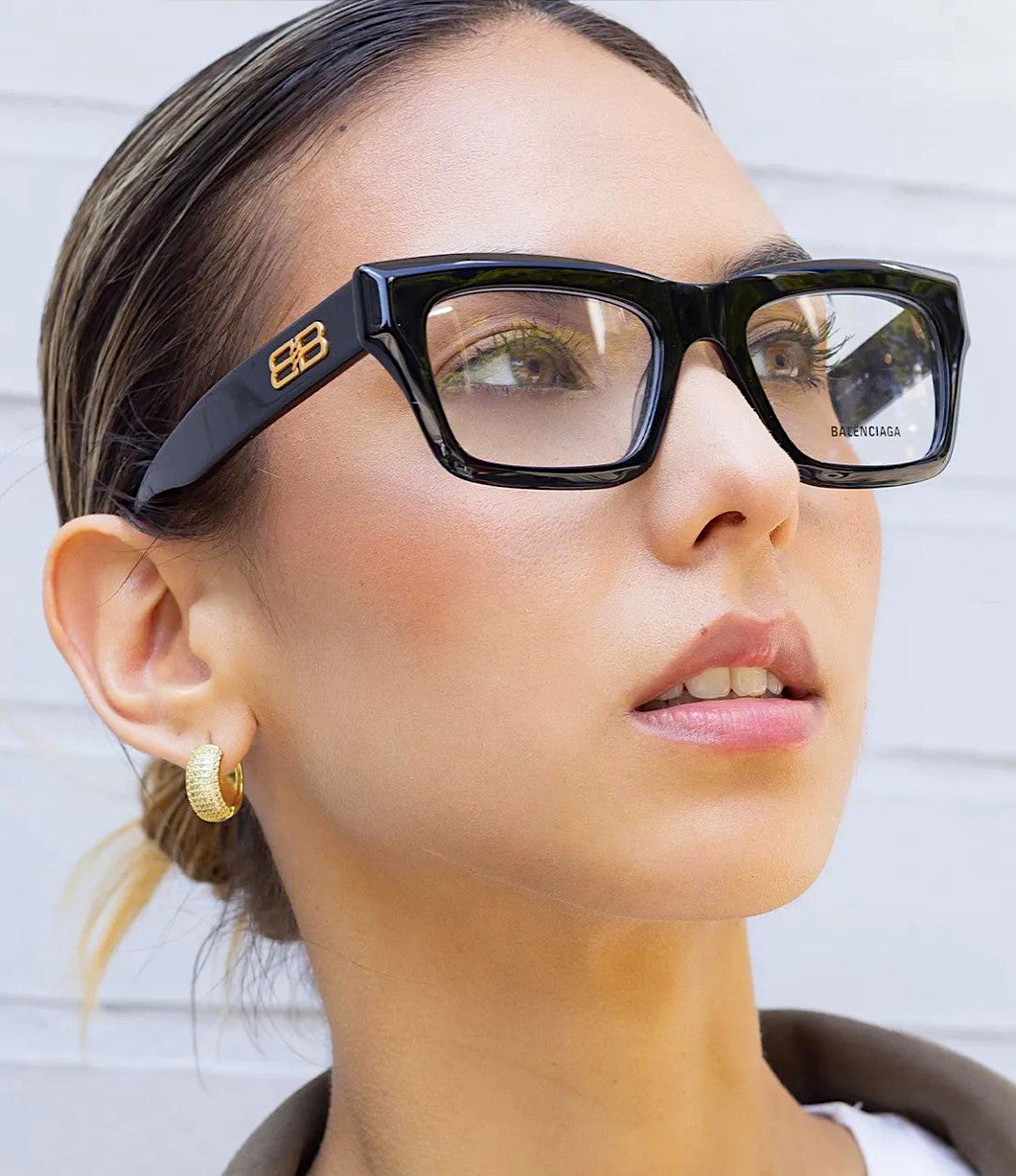 Balenciaga thick-rim black eyeglasses on face, square lenses with logo temples