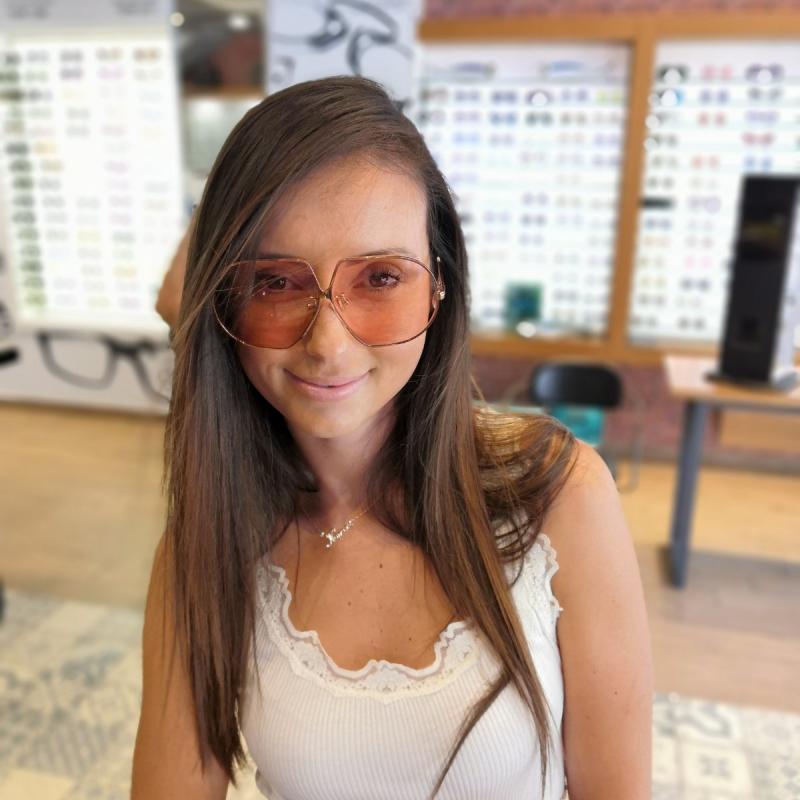 Oversized rose-gold sunglasses with pink lenses worn on a model