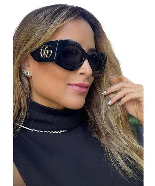 Black Gucci rectangular sunglasses with GG logo on frame, worn by model.