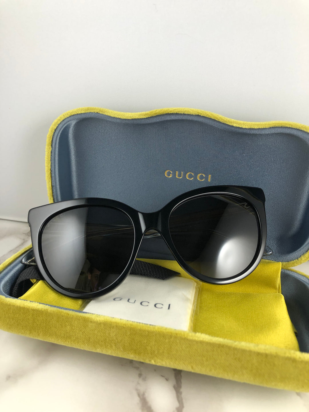 Gucci GG0565SN Gafas de sol negras con forma de ojo de gato y patas transparentes 