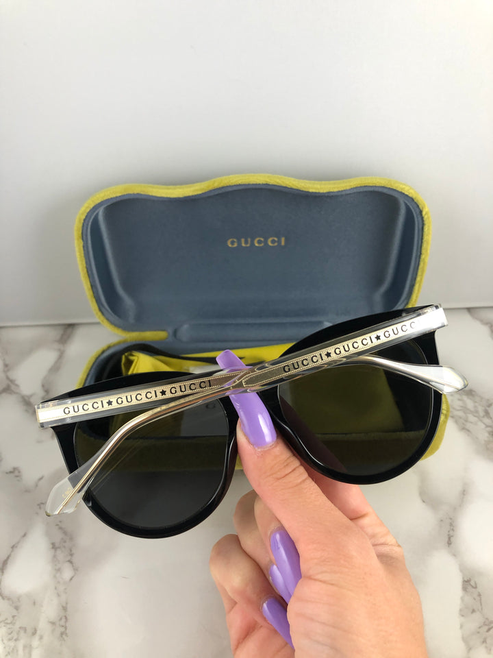 Gucci GG0565SN Gafas de sol negras con forma de ojo de gato y patas transparentes 